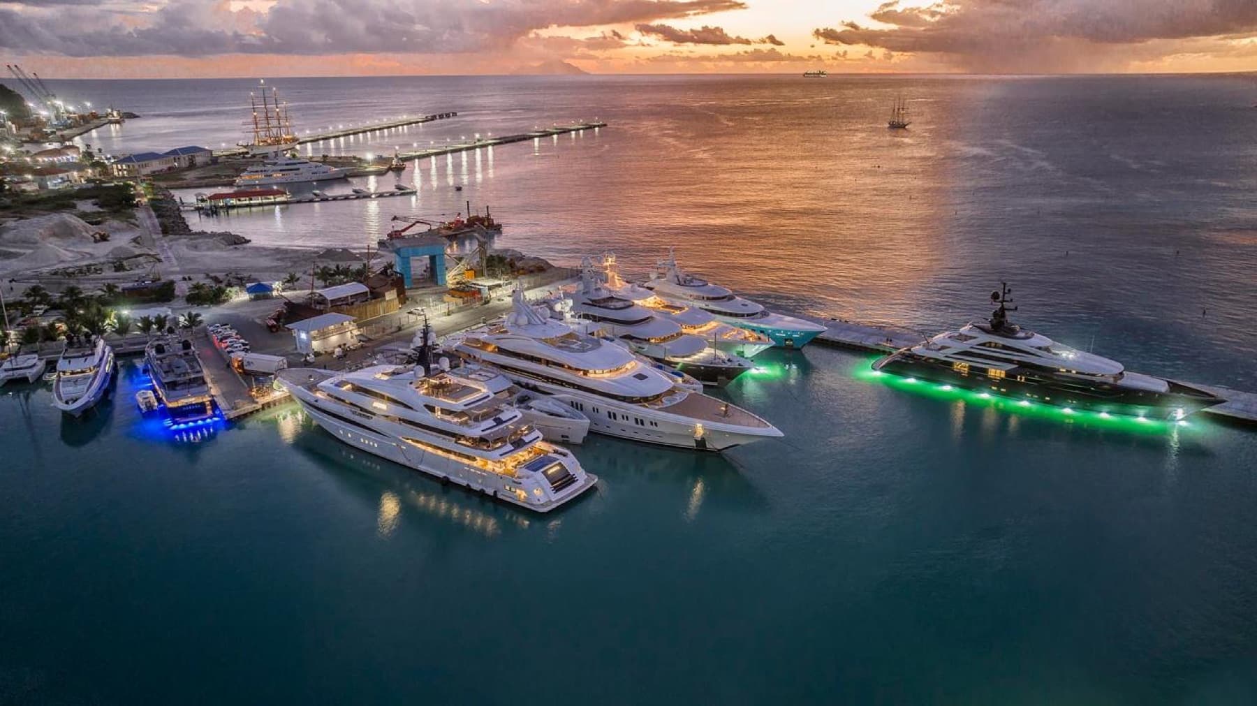 Several large yachts alongside a harbour at dusk
