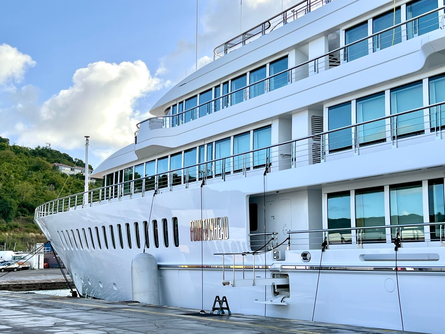 White megayacht alongside a working quay