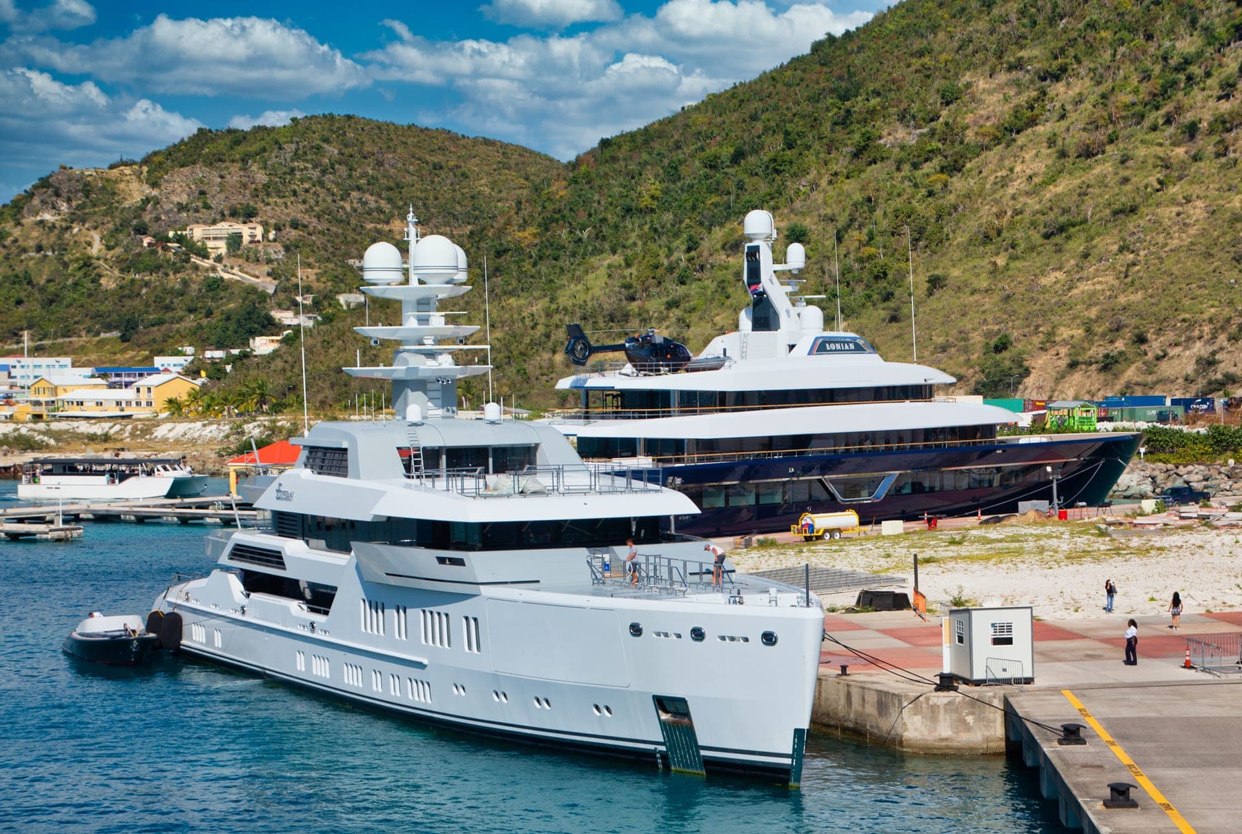 Two megayachts, one with a helicopter, docked in Sint Maarten